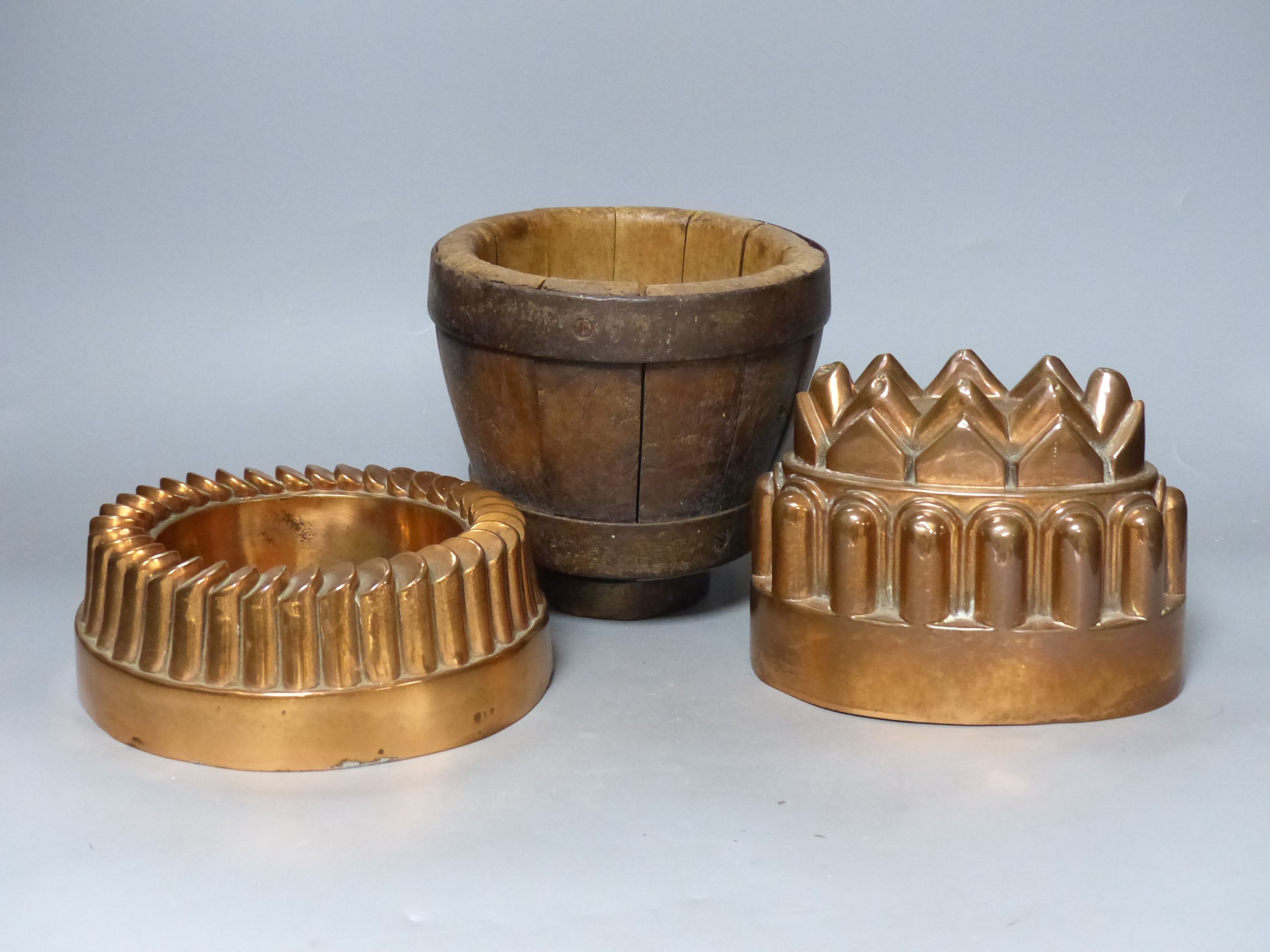 Two jelly moulds, and a wooden mortar